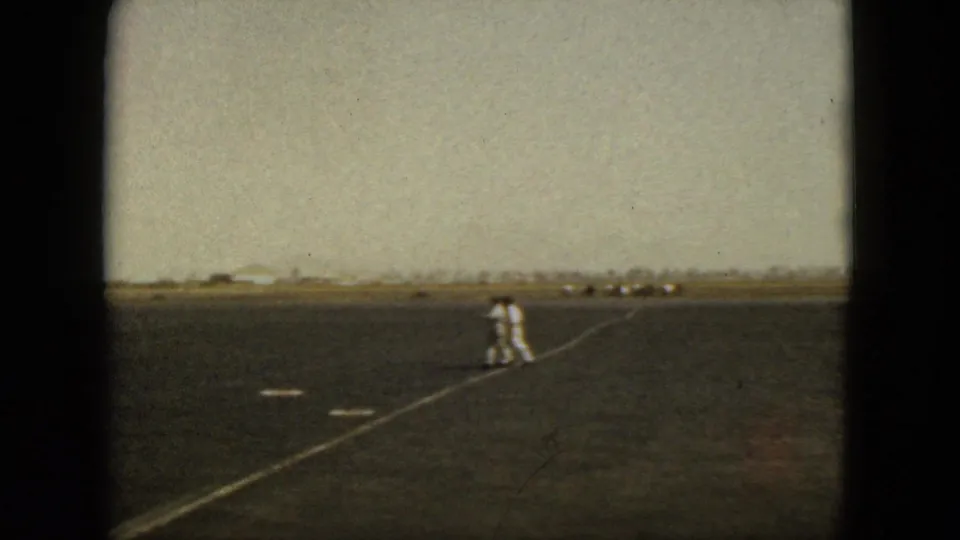 A ground crew member in a light uniform walks across the Acapulco airport tarmac in the 1962 home-movie footage.