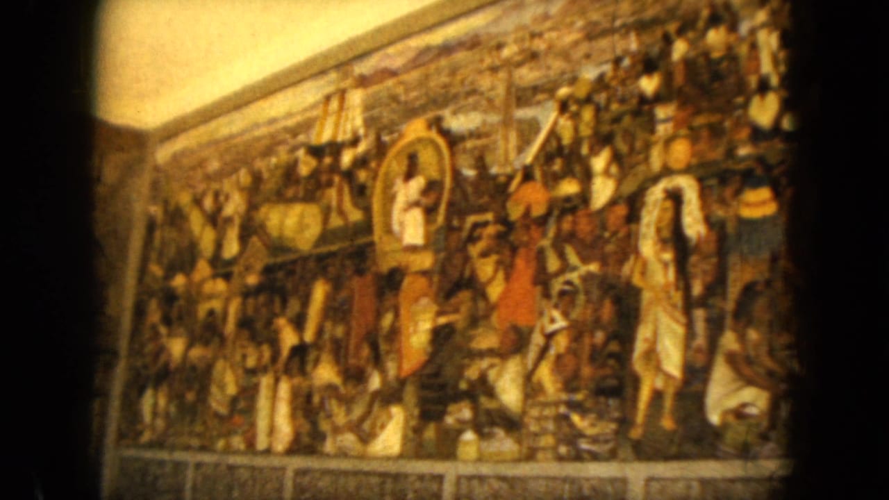 Handheld 8mm view of a colorful mural with many painted figures and dark film gate edges.