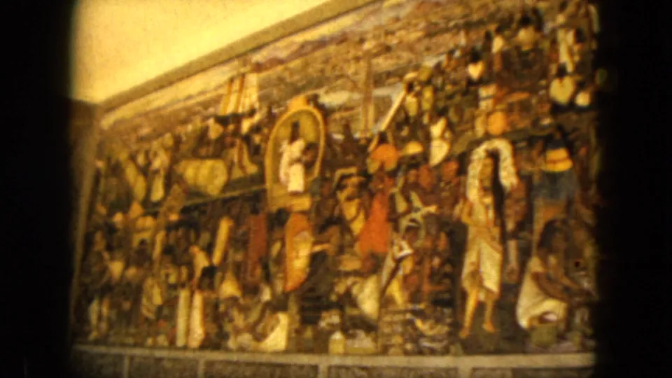 1962 Acapulco footage holds on the mural, showing clustered painted figures, earth tones, and handheld 8mm framing.