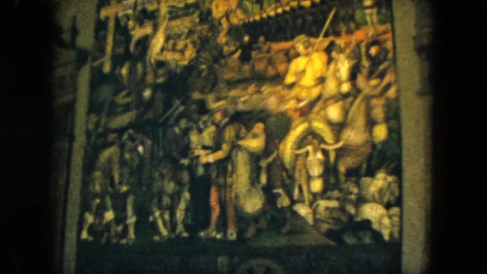 Soft 8mm frame from Acapulco in 1962 showing a closer view of the medieval battle tapestry, with horses, soldiers, and a bright mounted figure.