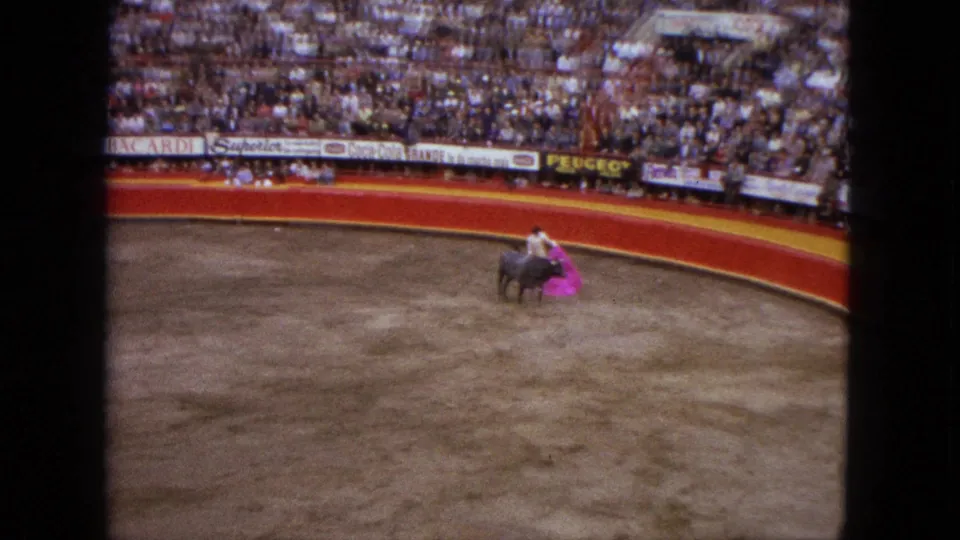 A bull moves toward the matador's pink cape during a 1962 Acapulco bullfighting scene filmed from the stands.