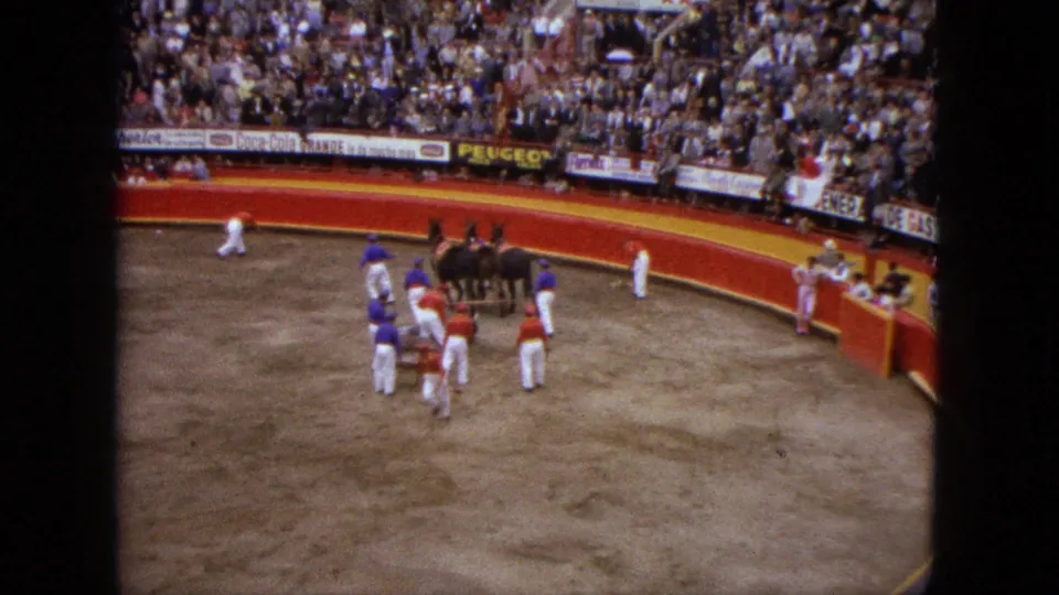 1962 Acapulco home-movie frame showing matadors, horses, and a bullfighting arena surrounded by spectators.