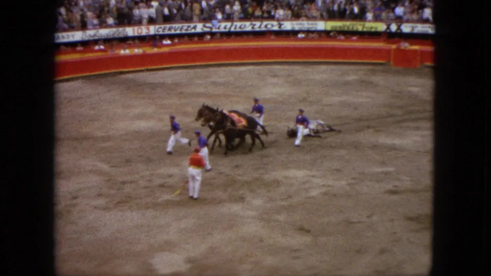 1962 Acapulco home-movie view of horses dragging an object in the bullfighting ring with matadors nearby.