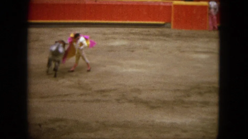 The matador leans with the cape while the bull moves past on the sandy floor of the Acapulco bullring.