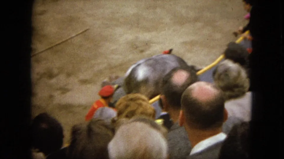 1962 Acapulco bullfighting footage shows spectators in the foreground watching a bull and horse in a dusty arena.