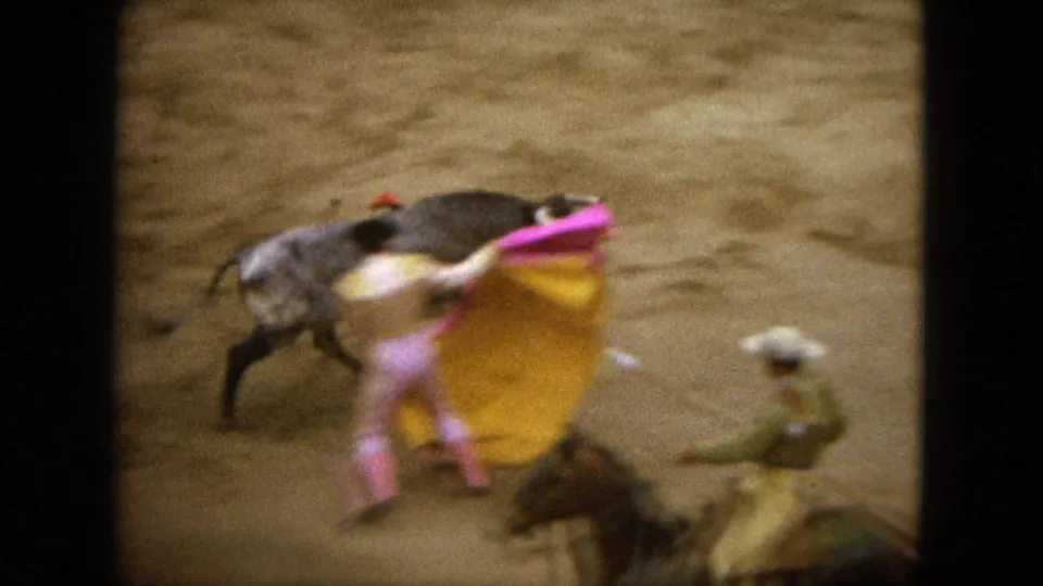 1962 Acapulco bullfight frame showing the bull close to the matador's cape, with a mounted horseman partly in view.