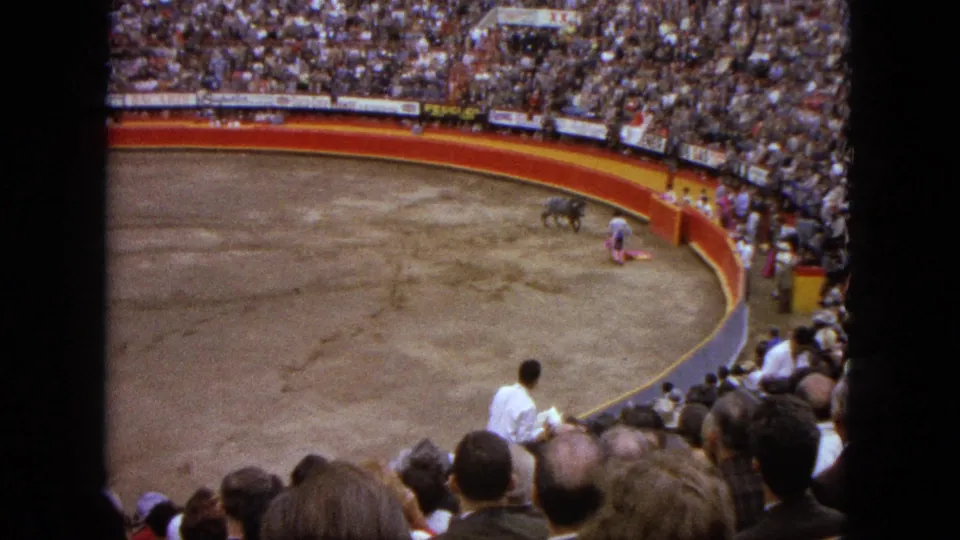Acapulco 1962 arena footage showing a matador crouched with a pink cape as the bull stands nearby.