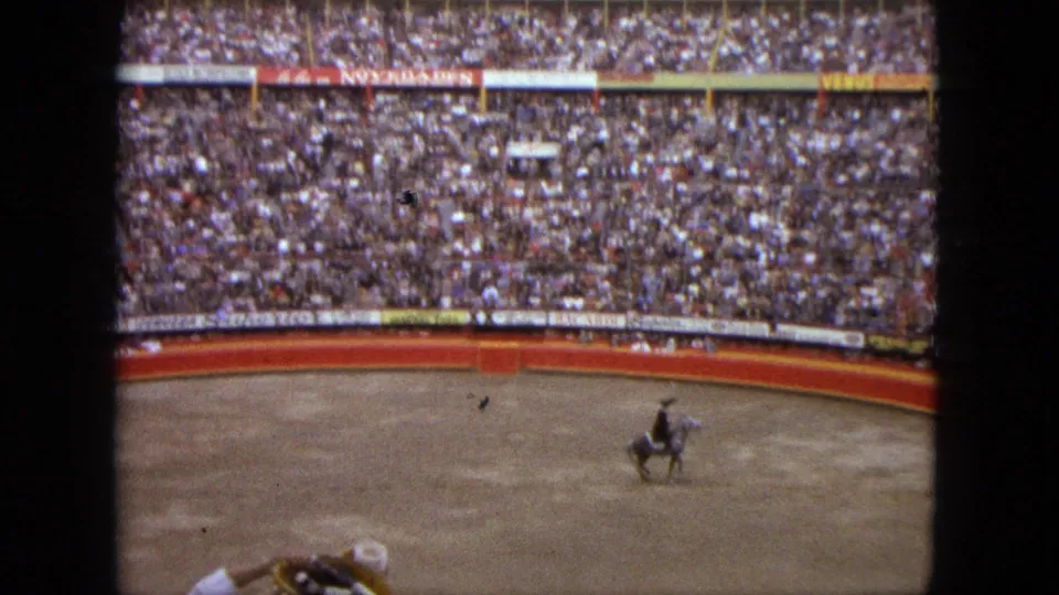 Wide 8mm view of the Acapulco arena, with a mounted rider low in frame and packed stands rising behind.