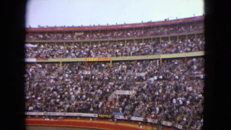 Wide interior frame of the Acapulco bullring, with signage along the stands and spectators filling the circular venue.
