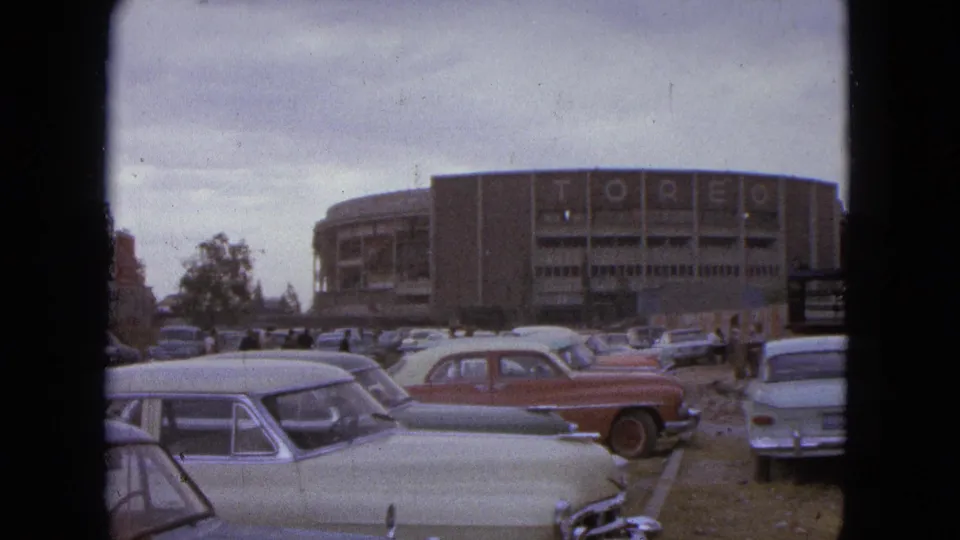 1962 Acapulco view of a crowded parking lot with classic cars and the TOREO-lettered building in the background.