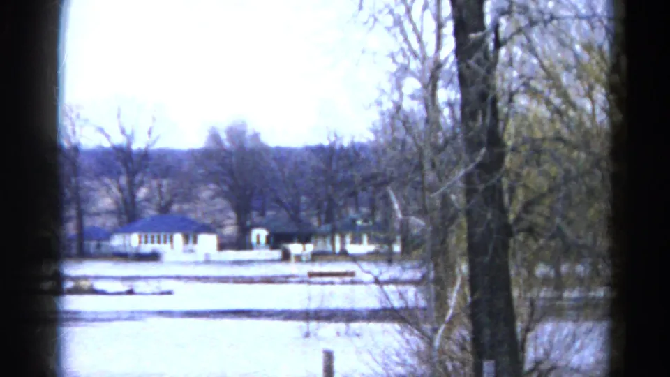 1961 Wauconda, Illinois flooded shoreline with bare trees and low buildings seen across high water.