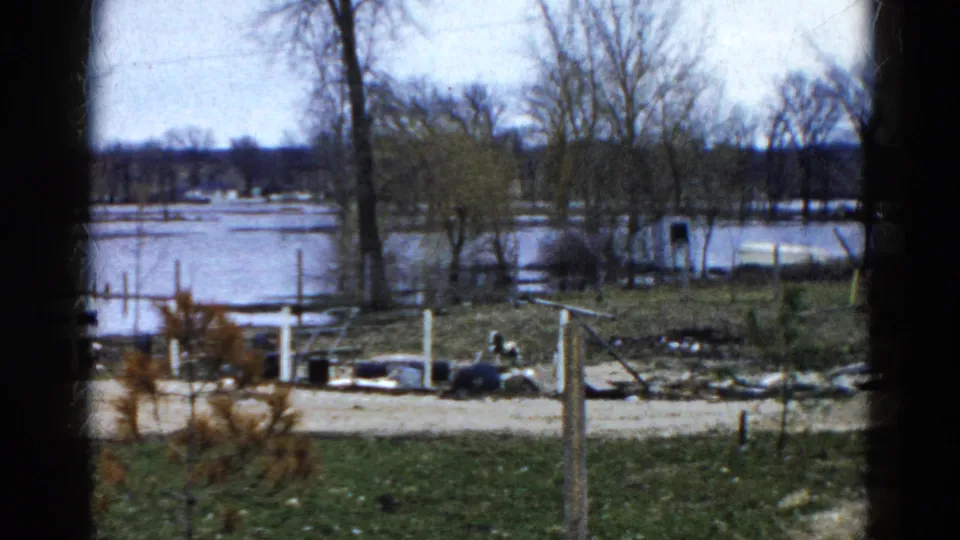 1961 Wauconda, Illinois view of a flooded lakeside yard, with docks and small boats near a high-water shoreline.