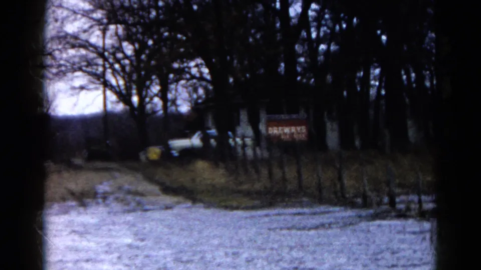 Floodwater covers part of a roadside in Wauconda, Illinois, with a white vehicle, fence posts, trees, and a BREWERS sign visible.
