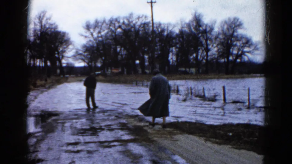The final frame shows the woman moving along the roadside in Wauconda while the man remains near the flooded section of road.