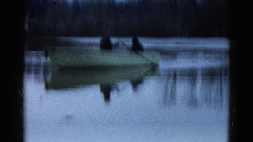 Soft 8mm frame from Wauconda, Illinois, showing the rowboat and its reflection on a quiet lake in 1961.