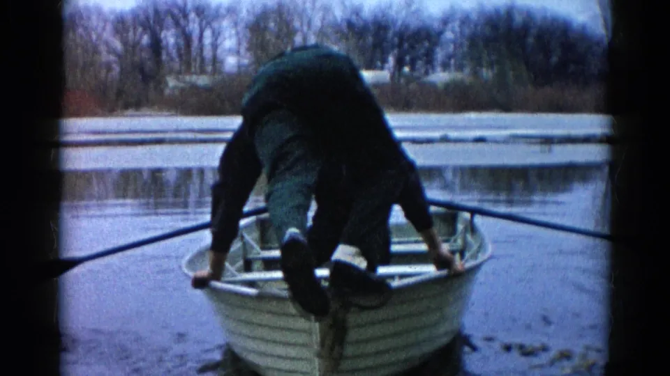 The man appears to lose balance across the small rowboat on a cold lake in Wauconda, Illinois, during the 1961 home-movie scene.