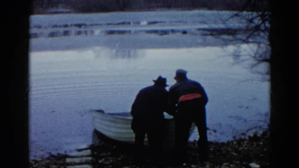 The adults appear to lift or steady the front of a small rowboat beside the lake in Wauconda, Illinois, 1961.