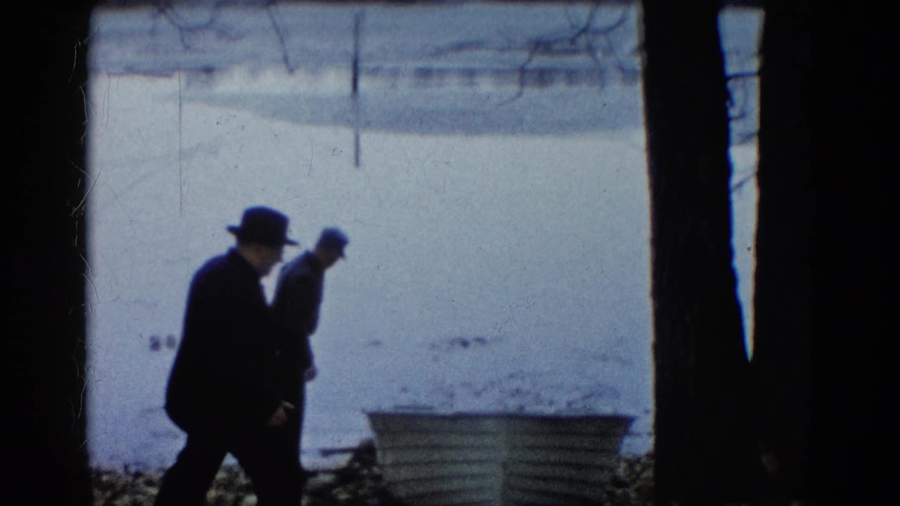In Wauconda, Illinois, two men in winter coats and hats approach a rowboat beside a frozen lake in 1961 home-movie footage.