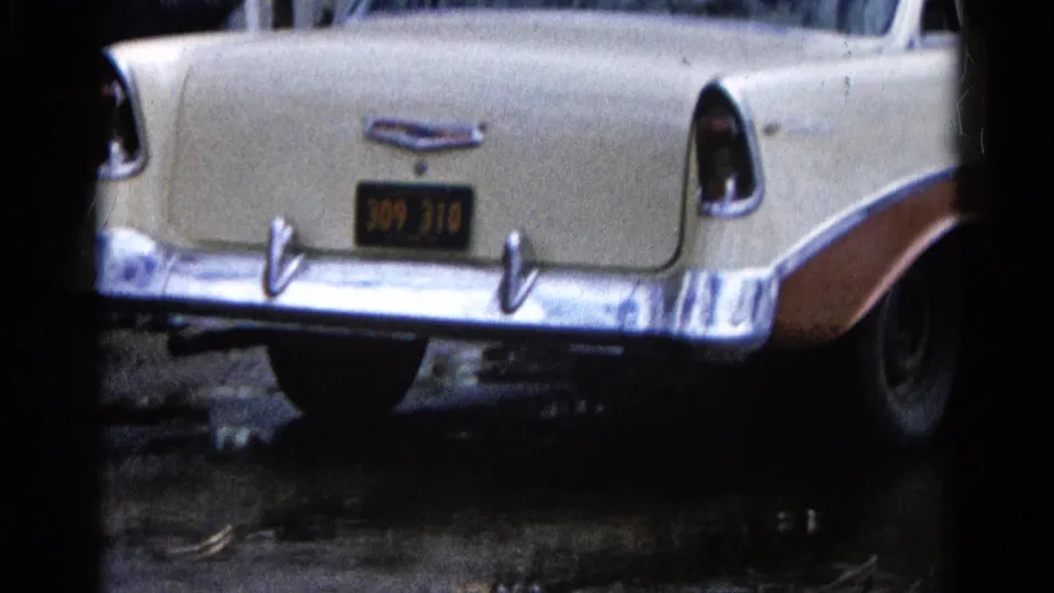 Two-tone Chevrolet Bel Air rear quarter framed by dark 8mm edges near flooded shoreline in Wauconda.