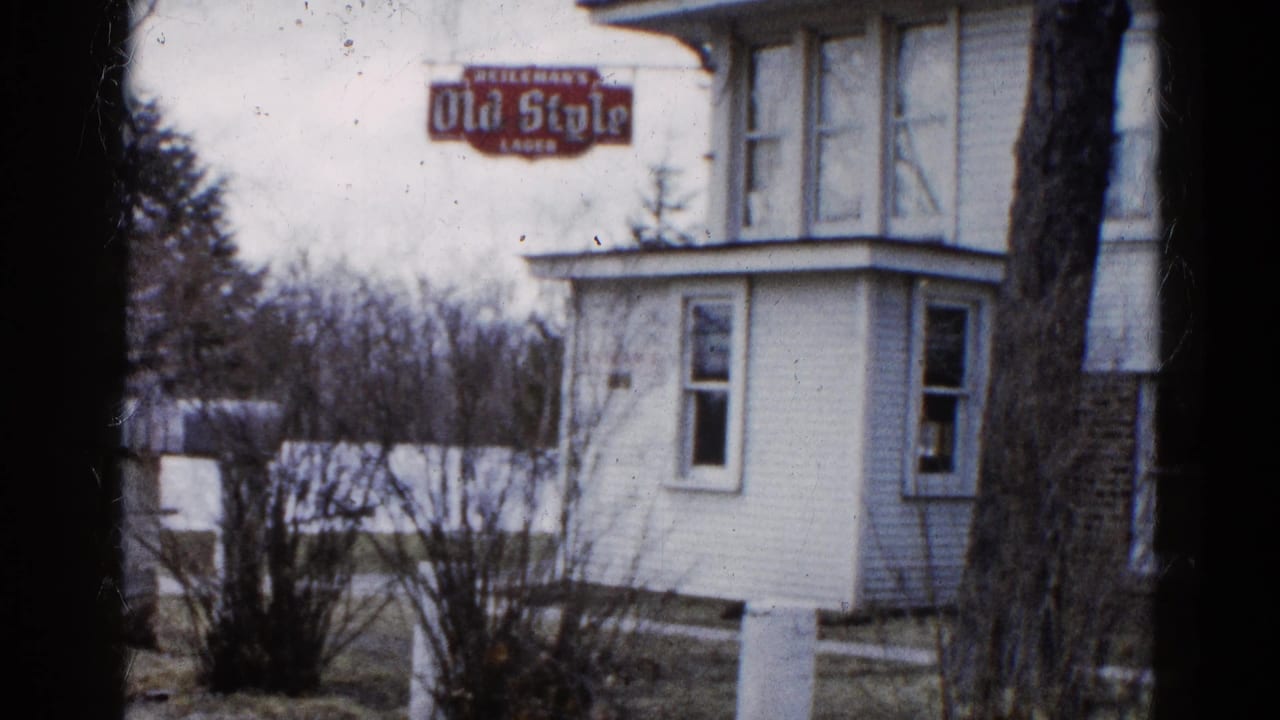 White house exterior with a red Old Style Lager sign above the porch and bare shrubs in front.