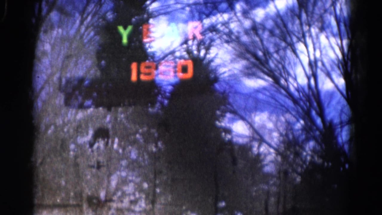 In this 1961 Wauconda 8mm frame, YEAR 1960 glows in color against a dark window view with leafless branches.