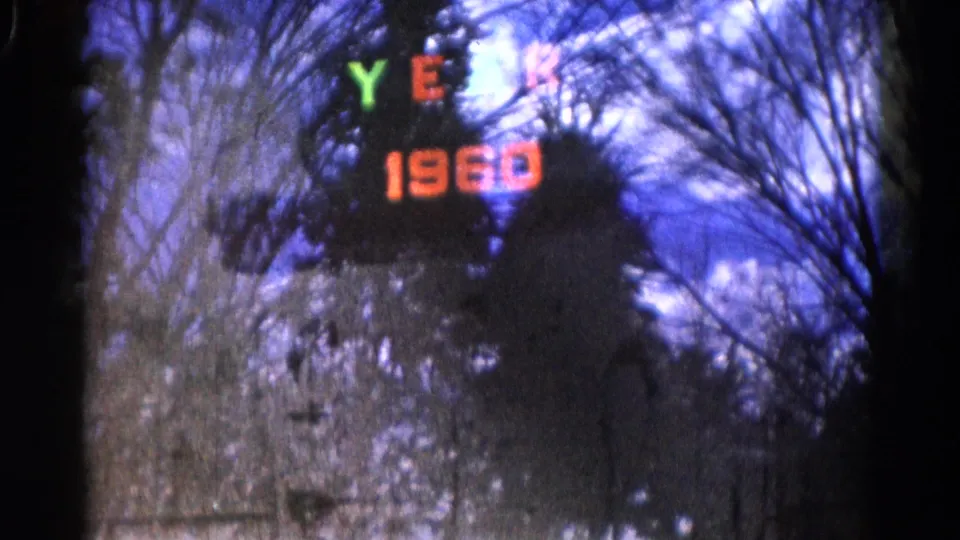 The final 1961 Wauconda frame shows the YEAR 1960 display softened by 8mm grain, with leafless trees visible through or on glass.