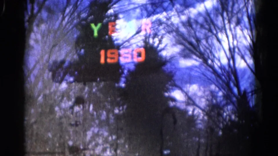 Final 8mm frame with a blurred “YEAR 1960” title over leafless trees and deep blue winter sky in Wauconda, Illinois.