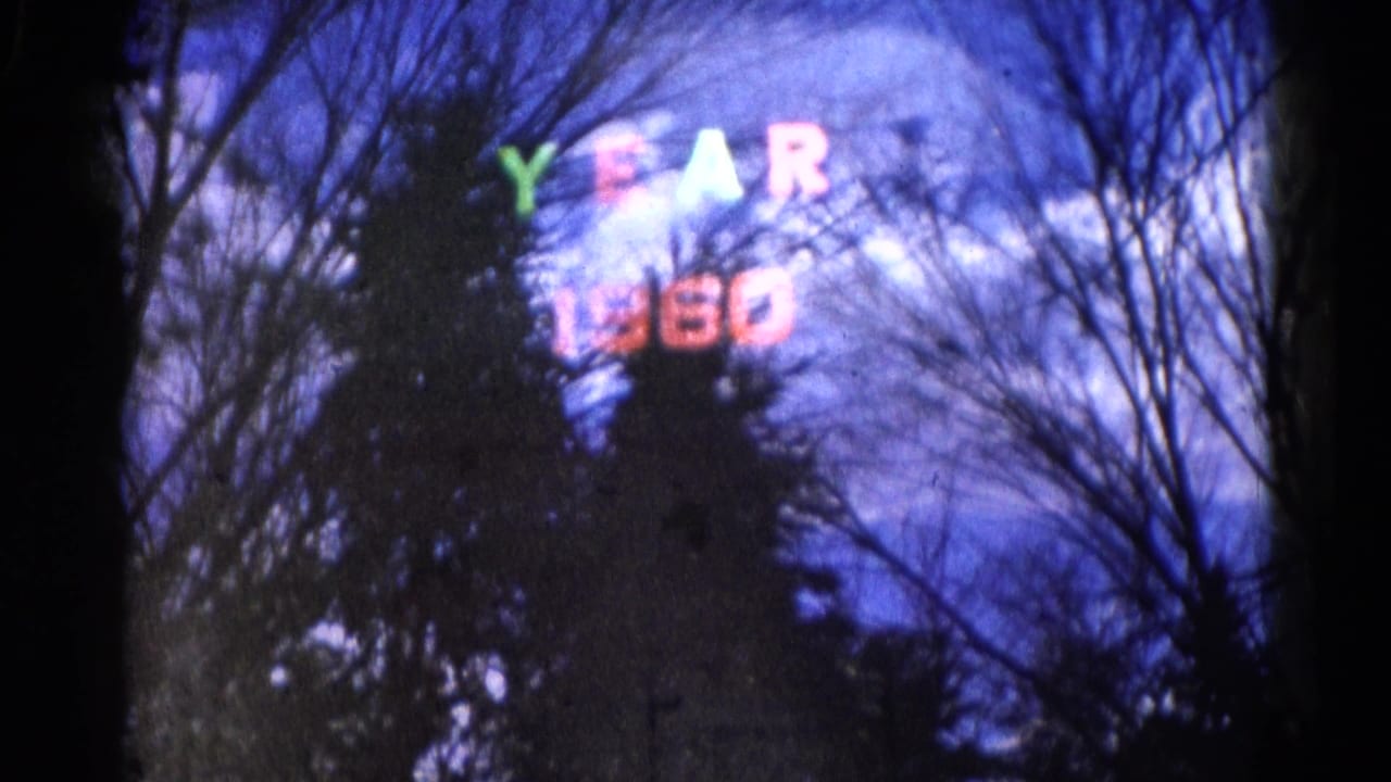Colorful "YEAR 1960" lettering partly obscured by dark winter tree silhouettes.