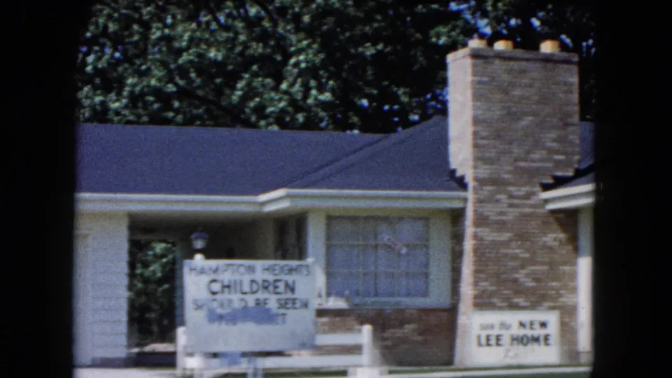 1961 South Carolina frame showing a suburban house exterior with Hampton Heights Children's Center signage and a Lee Home sign near the chimney.