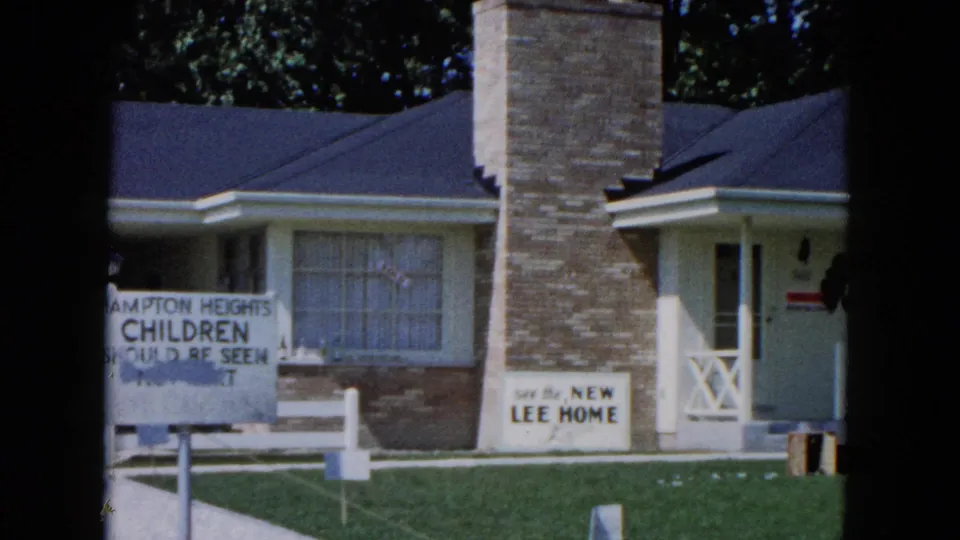 1961 South Carolina frame of a suburban house with a front sign mentioning children and another sign advertising a new Lee home.