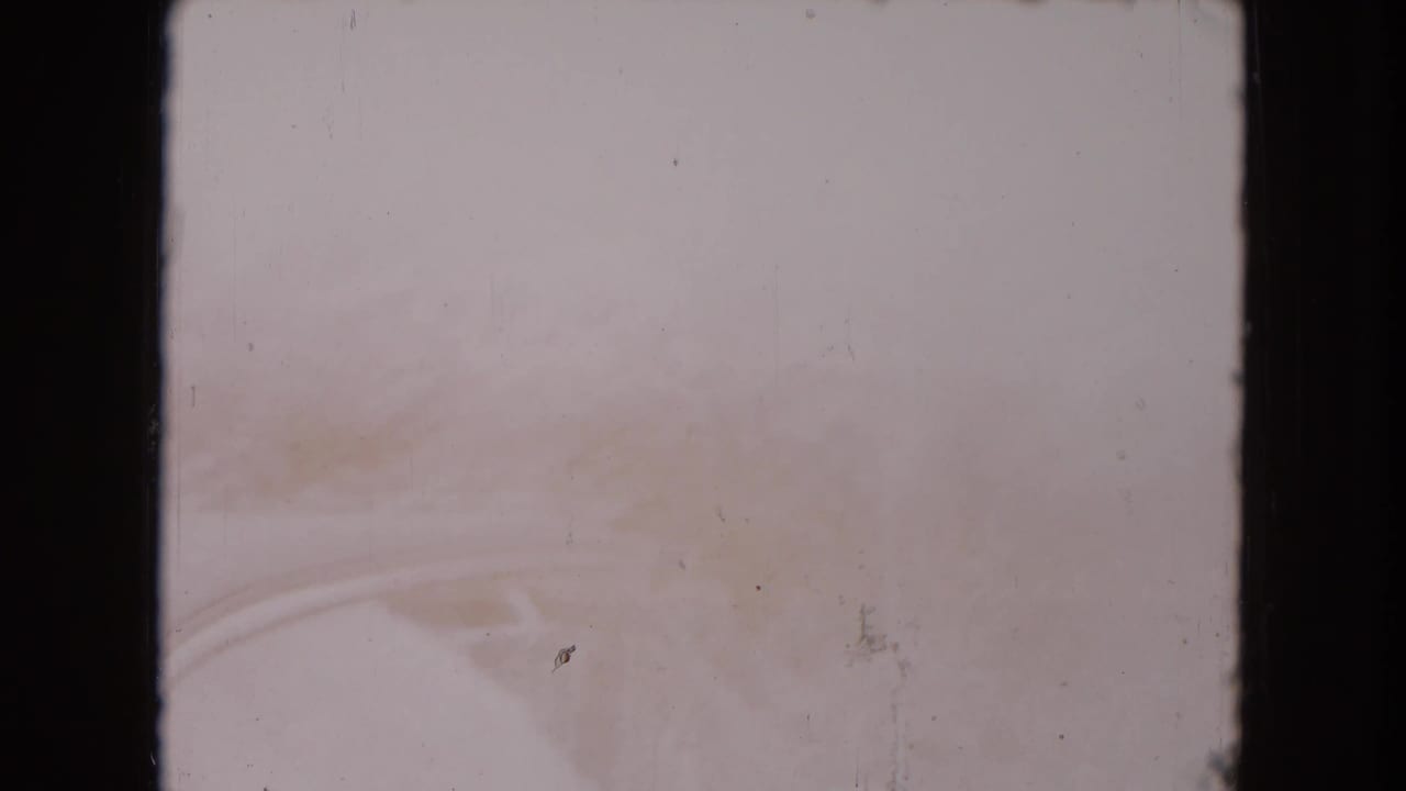 Overexposed car-side view with faint window and body outlines visible.