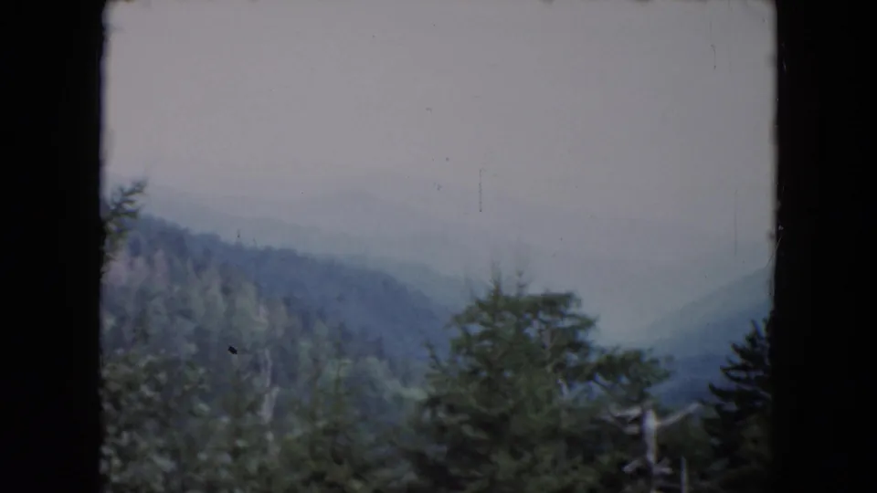 1961 home-movie view of a misty South Carolina valley with wooded slopes and evergreen foreground.