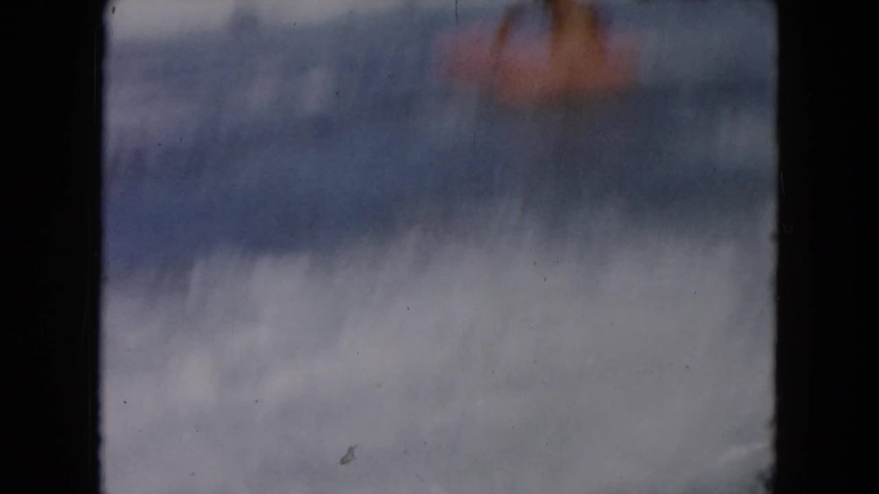 Soft 8mm frame from the South Carolina beach clip, showing blurred surf and sky with the subject not clearly visible.