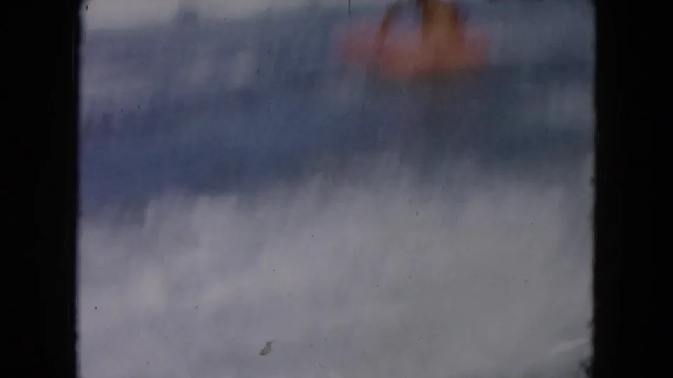 Soft 8mm frame from the South Carolina beach clip, showing blurred surf and sky with the subject not clearly visible.