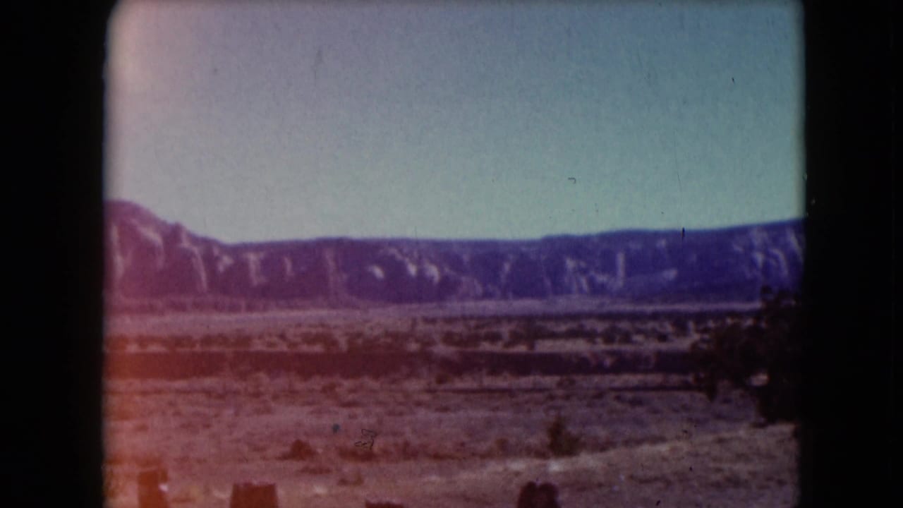 Desert landscape and distant ridge line with reddish fading along the lower left edge.