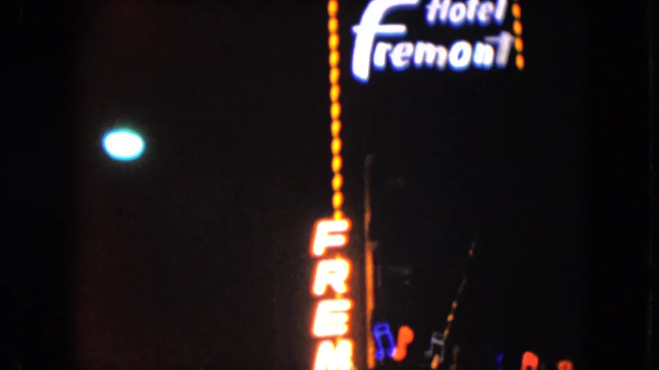 1961 Nevada night footage showing the Hotel Fremont neon sign and partial casino signage in a dark street scene.