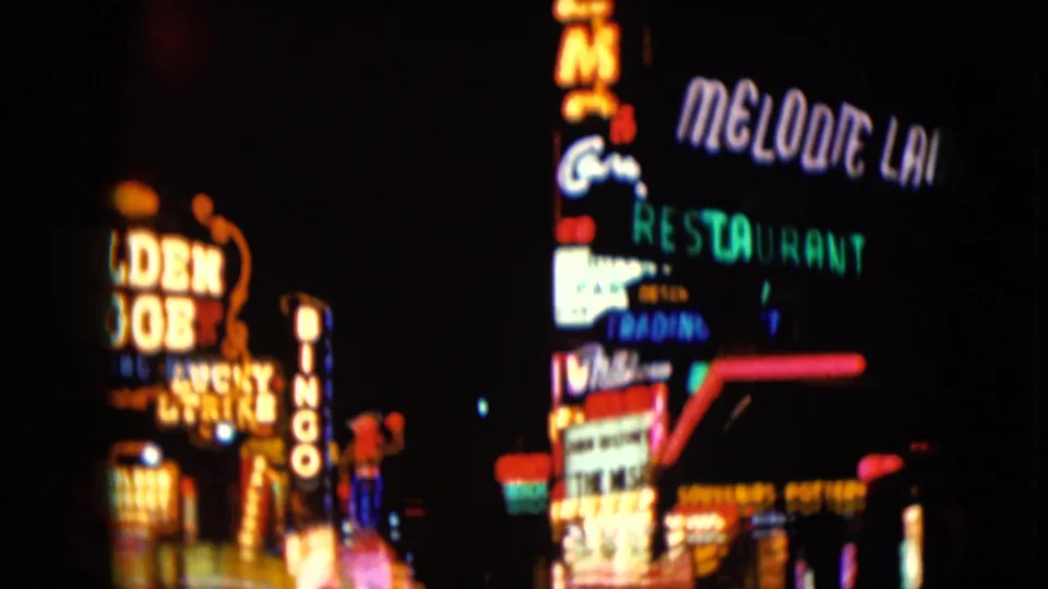 1961 Nevada 8mm frame showing casino and restaurant neon, including Golden Nugget, Melodie Lane Restaurant, and a vertical bingo sign.