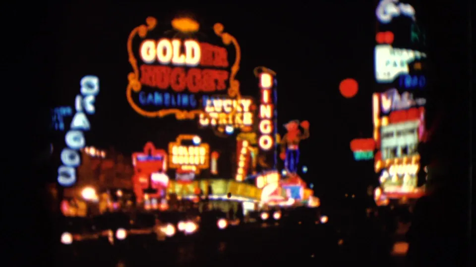 A closer 1961 Las Vegas night view centers the Golden Nugget sign, with adjacent casino and marquee lights visible in soft color.