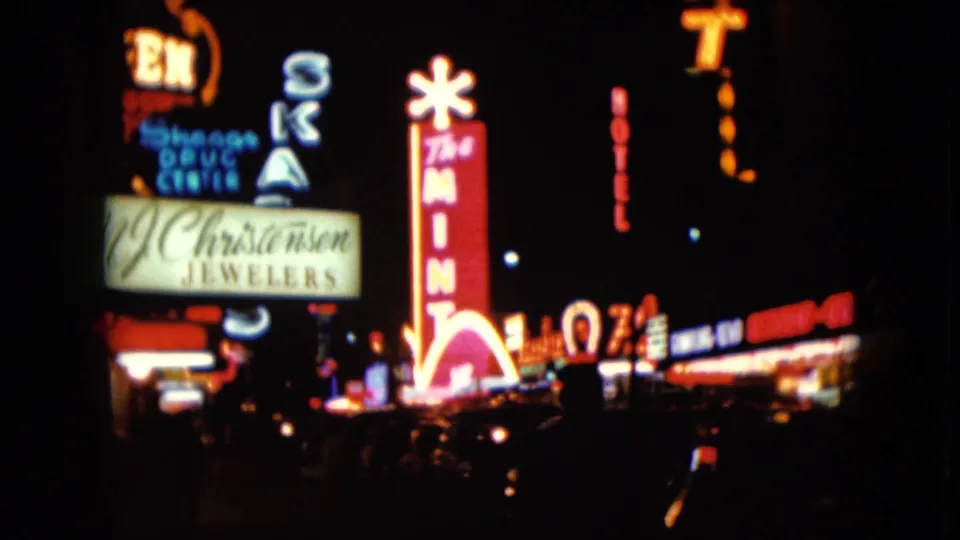 1961 Nevada downtown night view with The Mint sign, Christensen Jewelers sign, and glowing commercial frontage.