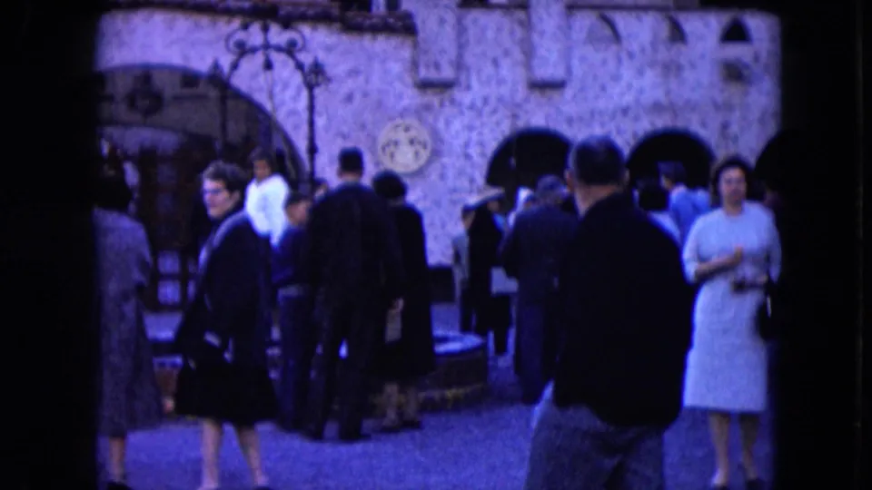 Adults outside a Nevada stone building in 1961, including a woman in a light dress and several people facing the doorway.