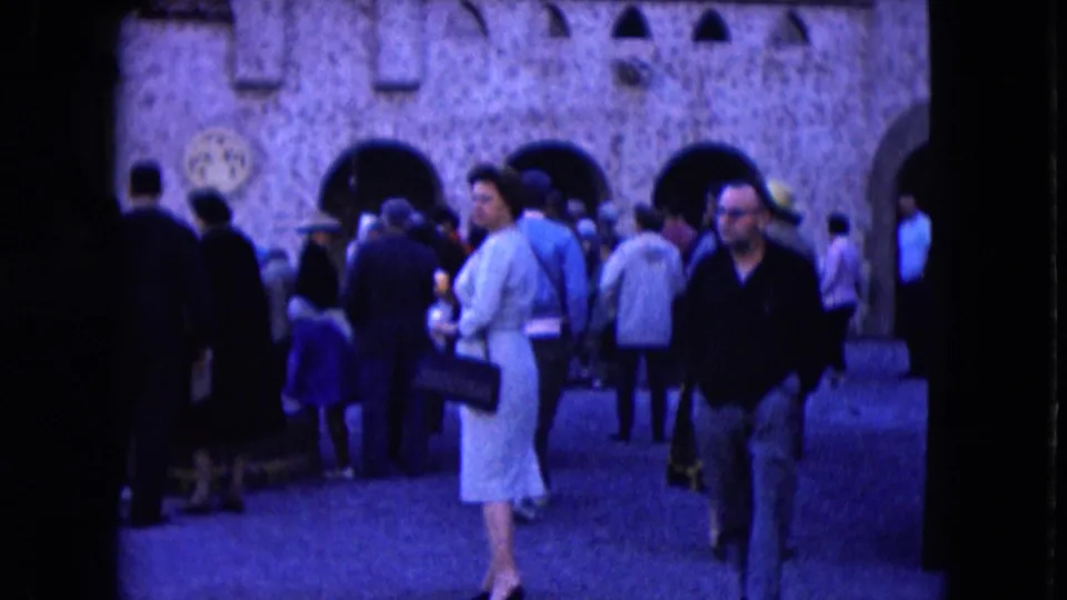 1961 Nevada tourist-attraction scene with visitors crossing a courtyard before arched stone walls and a ticket booth.