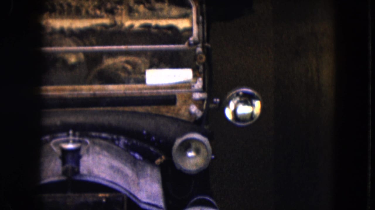 Close view of an antique car front with round headlight and curved fender.