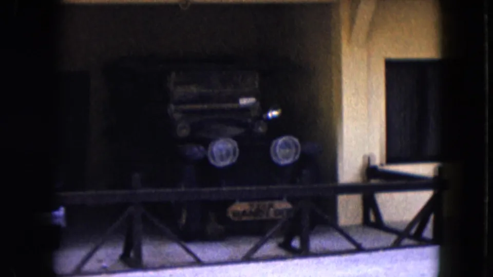 The final frame centers a dark antique automobile with twin round headlights behind a railing in a shaded 1961 Nevada display scene.