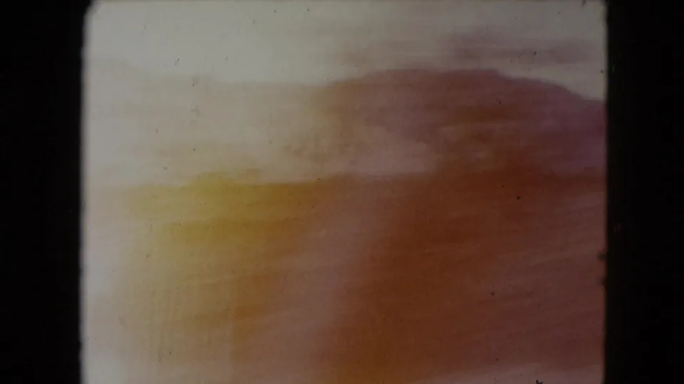 End frame from the 1961 Nevada road sequence, with warm blur, scrubby terrain and a low hill form.