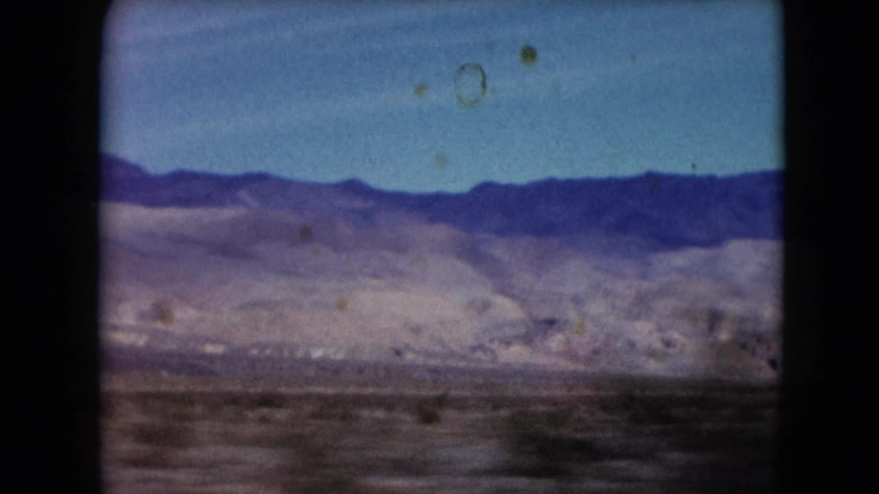 Mountain ridge and pale desert basin seen through a soft 8mm frame.