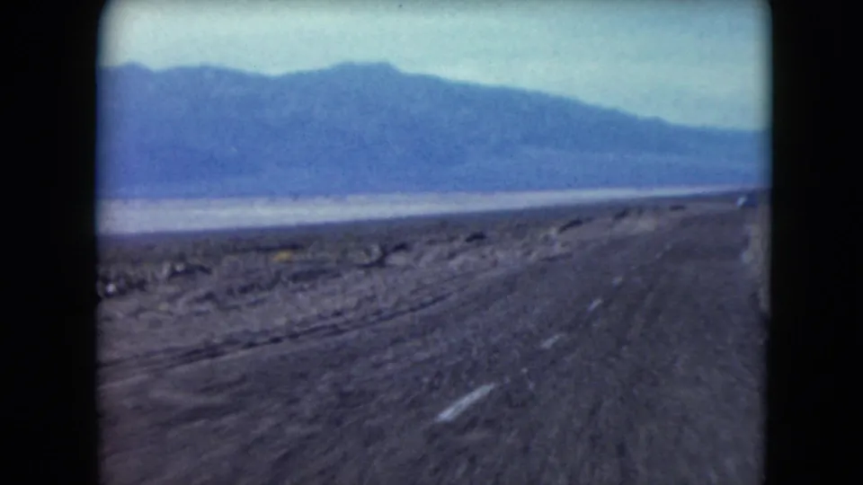 The final 1961 Nevada frame shows a blacktop road through sparse desert with blue mountains in the distance.