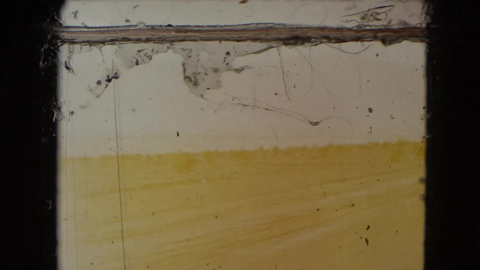 1961 Nevada 8mm frame showing a pale sandy desert view with a faint road surface and visible film wear at the top.