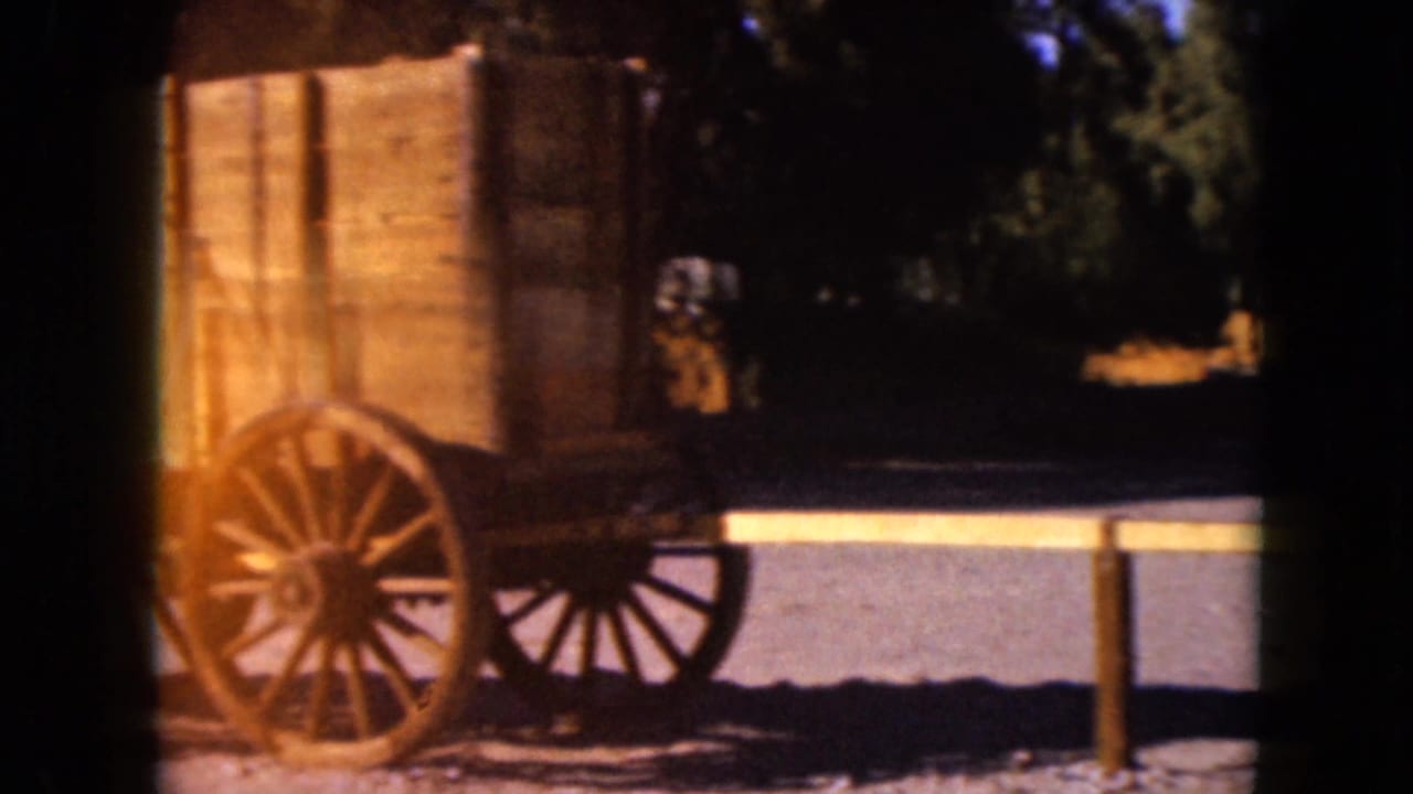 1961 Nevada 8mm frame showing a wooden Old West-style wagon with spoked wheels in bright sun and deep shadow.