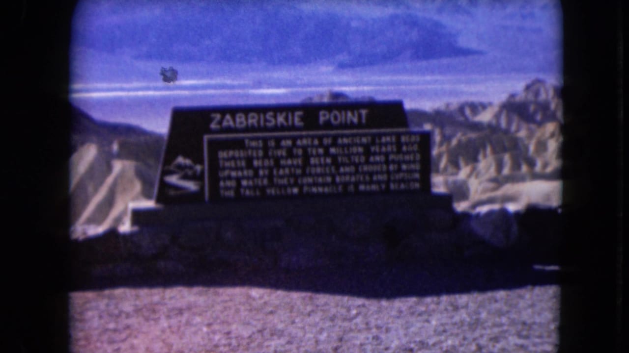 Zabriskie Point sign centered with desert ridges in the background.