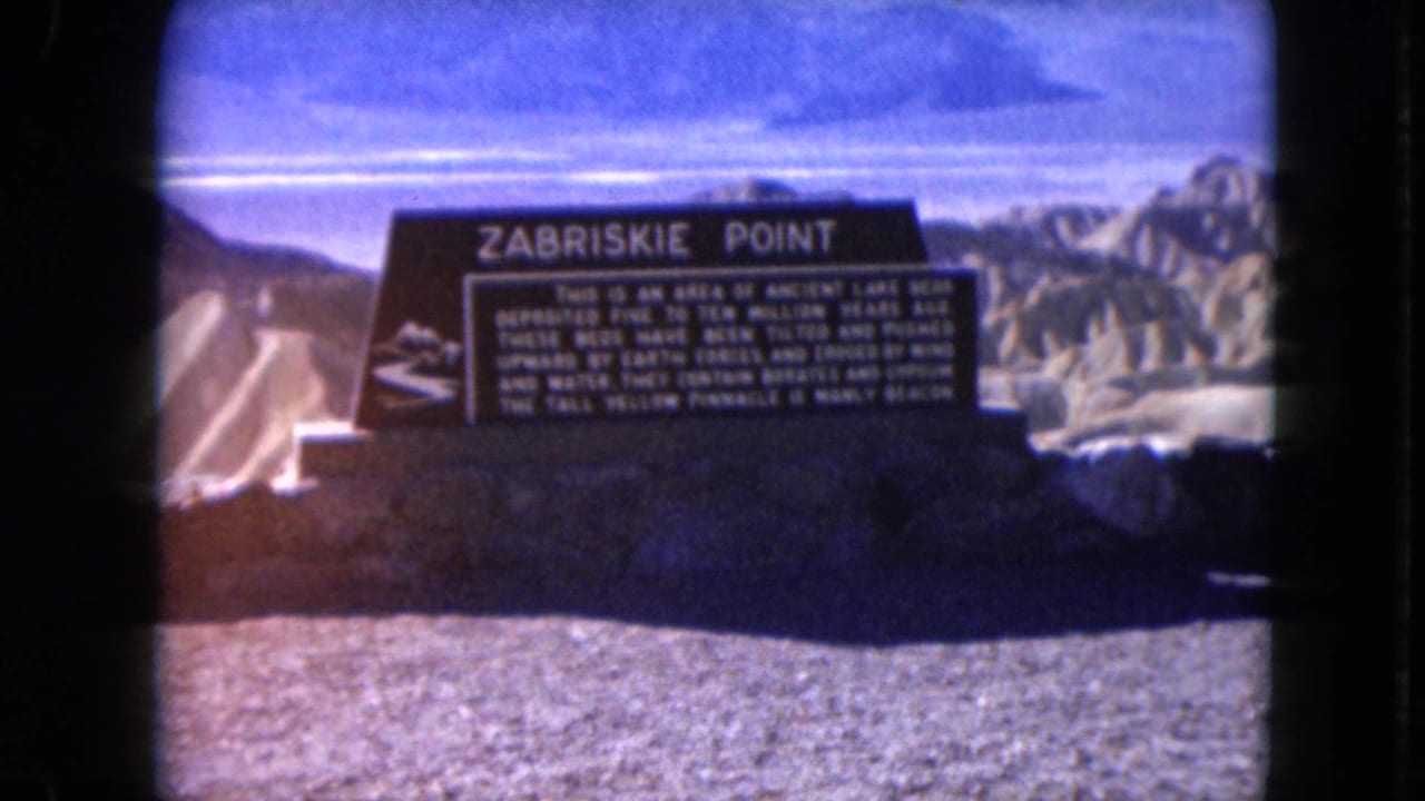 Zabriskie Point sign centered against pale desert ridges.